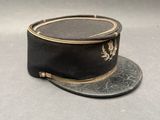 un chapeau noir orné d'une feuille d'or