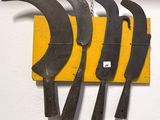 cinq couteaux accrochés à une planche jaune sur le mur