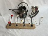un support en bois sur lequel sont posés un arrosoir, un arrosoir et plusieurs figurines