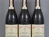 trois bouteilles de vin sont posées sur une table en verre
