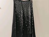 une jupe noire à pois blancs accrochée à un mur