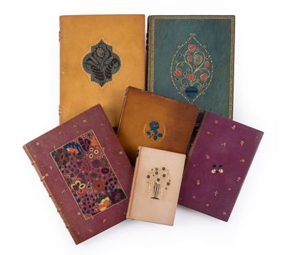 quatre vieux livres sont alignés sur une surface blanche