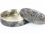 une petite boîte en argent ornée d'un motif floral