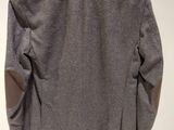 the back of a gray jacket hanging on a white hanger