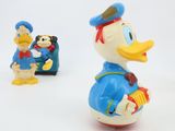 toy figurines of donald duck and donald the duck with suitcases