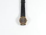 an image of a black and gold wrist watch on a white surface