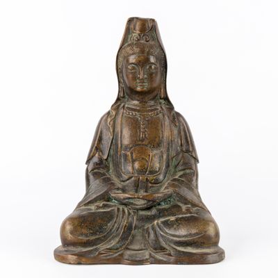 une statue en bronze représentant une femme assise en position du lotus