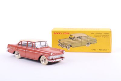 a red toy car next to a yellow box on a white surface