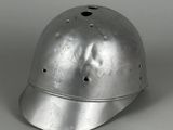 un vieux casque en argent troué, posé sur une table