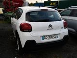 a white car parked in a parking lot next to other cars