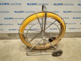 an image of a hose on a cart in front of a wall