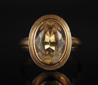 un gros plan d'une bague en or sertie d'un diamant jaune facetté