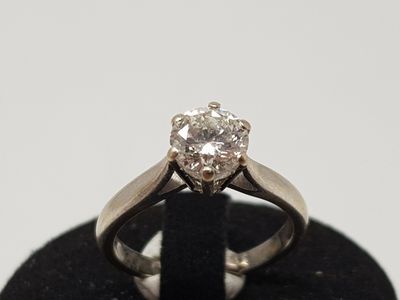 un gros plan d'une bague en diamant posée sur un socle noir