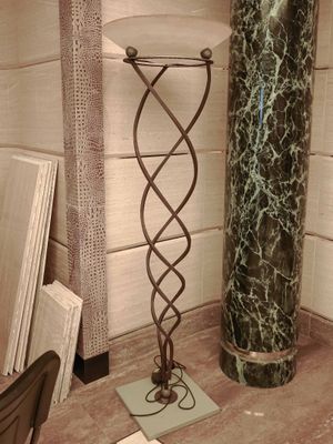 a lamp that is on a stand in the corner of a room