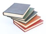 several books stacked on top of each other on a white surface
