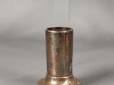 a small metal cup sitting on a table