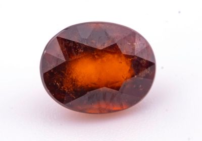 une photo d'une pierre précieuse de forme ovale, de couleur marron et orange