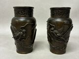 pair of bronze vases with birds on them on a white background