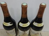 three bottles of wine that are sitting on the floor