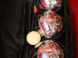 three balls in a case with a wooden spoon in it