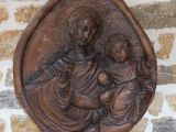 une image représentant une statue de femme tenant un enfant, accrochée au mur