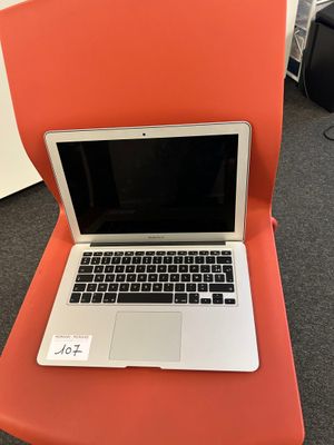 an orange chair with a laptop on top of it in a room