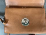brown leather purse with a silver coin on the front of it
