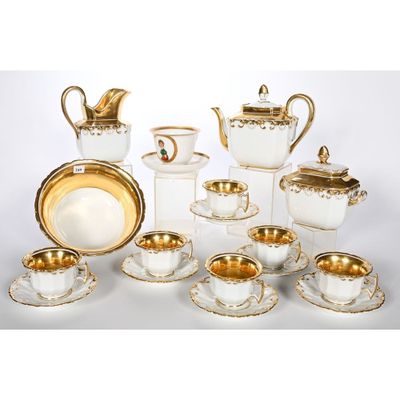 une image représentant un ensemble de plats et de tasses blancs et dorés