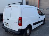 une camionnette blanche garée devant un bâtiment