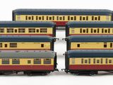 six toy train cars are lined up on a white surface