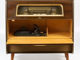 an old fashioned radio sitting on top of a wooden cabinet