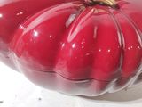 a red plastic pumpkin sitting on a white table