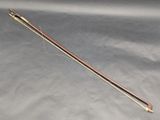 a close up of a wooden stick with a needle on a gray surface