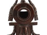 une horloge en bois surmontée d'un oiseau