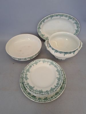quatre pièces de vaisselle verte et blanche posées sur une table