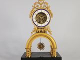 une horloge dorée avec un cadran bleu sur un socle noir