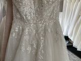 the wedding dress is hanging on the rack in the bridal shop