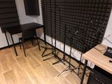 a room with a desk, speakers, and a sound wall