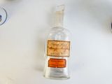 a glass bottle with a label on it sitting on a table