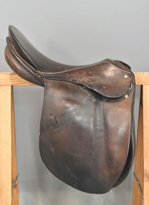 un gros plan d'une selle marron posée sur un support en bois