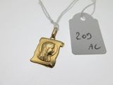 une photo d'un collier en or orné d'une image de Jésus