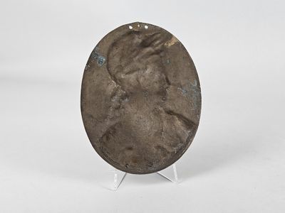 an image of a bronze plate with a woman ' s face on it