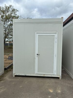 deux toilettes portables placées l'une à côté de l'autre sur un parking