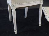 a white chair and a small table on a black background