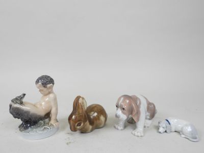 three figurines of a boy sitting on a bench with a dog and a cat