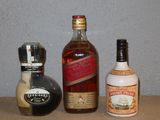 trois bouteilles d'alcool posées les unes à côté des autres sur une table