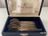 a set of silverware in a blue box on a table