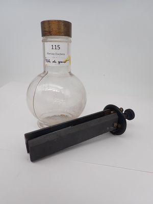 une bouteille d'alcool posée à côté d'une pipe sur une table