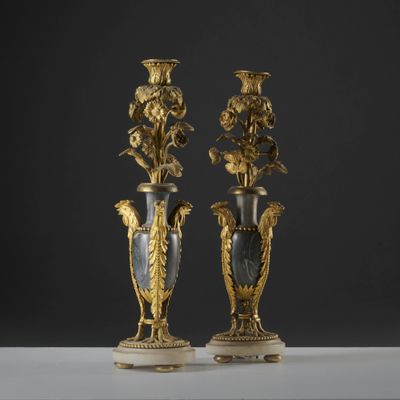une paire de vases anciens ornés de fleurs, posés sur des socles en marbre, sur une table