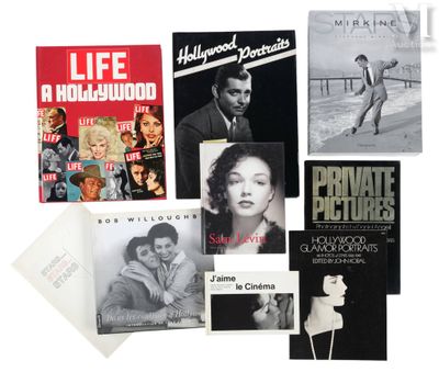 Plusieurs livres sont empilés les uns sur les autres sur une surface blanche.